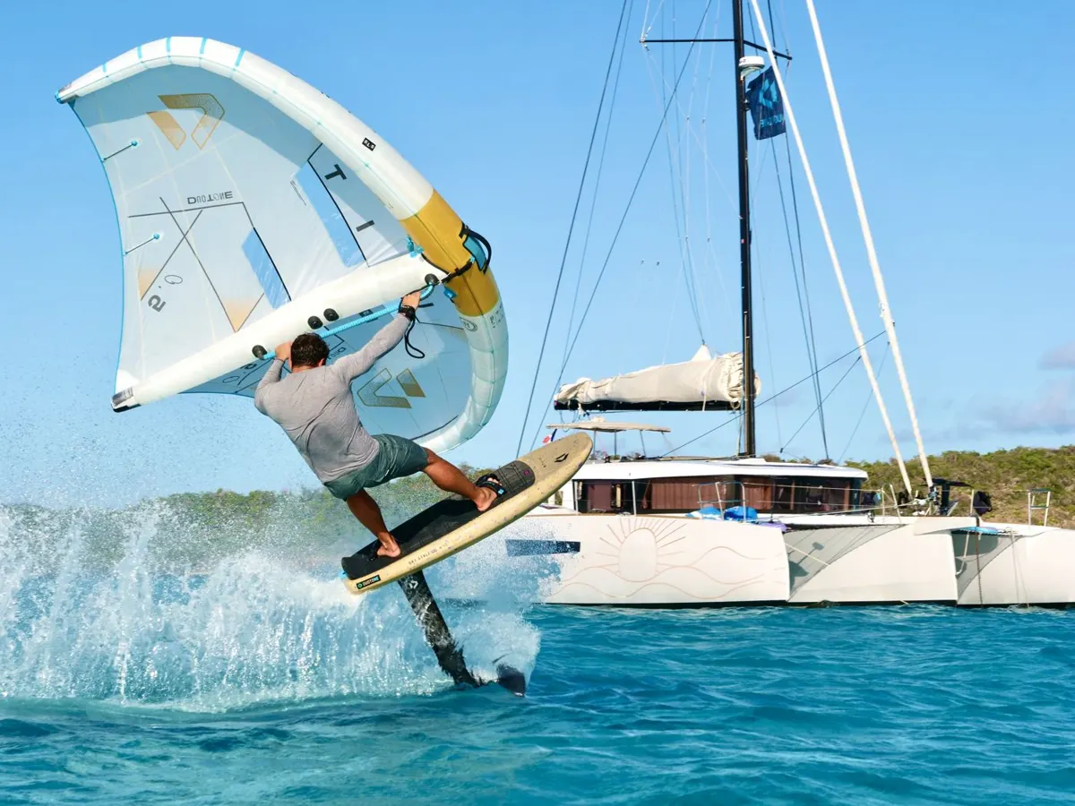 Saut en wingfoil devant le catamaran