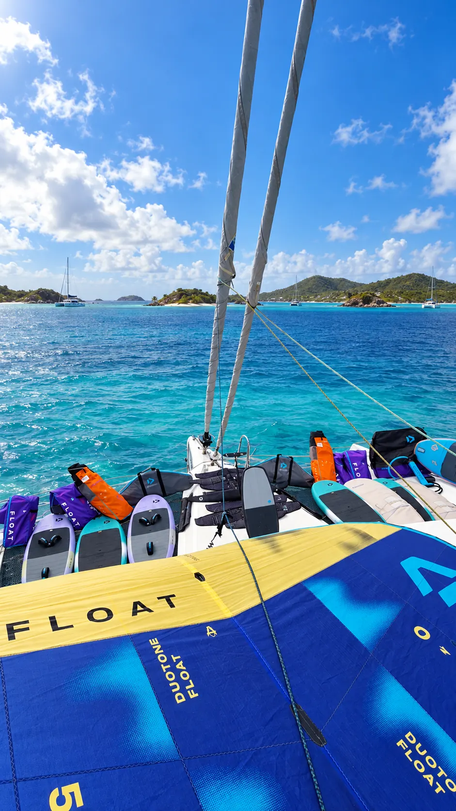 Quiver Duotone complet — ailes, boards et foils — préparé sur le pont d'un catamaran au mouillage